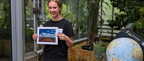 Das Foto zeigt eine Studentin an der Ananas-Station ihres Workshops im Tropenschauhaus des Botanischen Gartens.